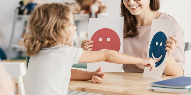 child pointing to happy face at therapist office