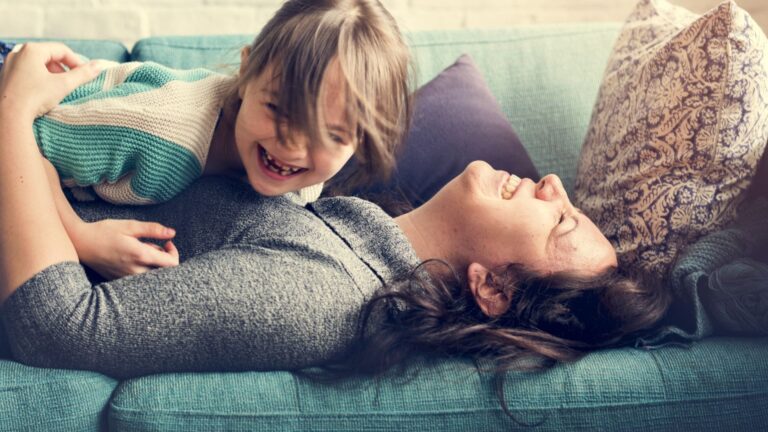 woman in her 40s laughing with daughter